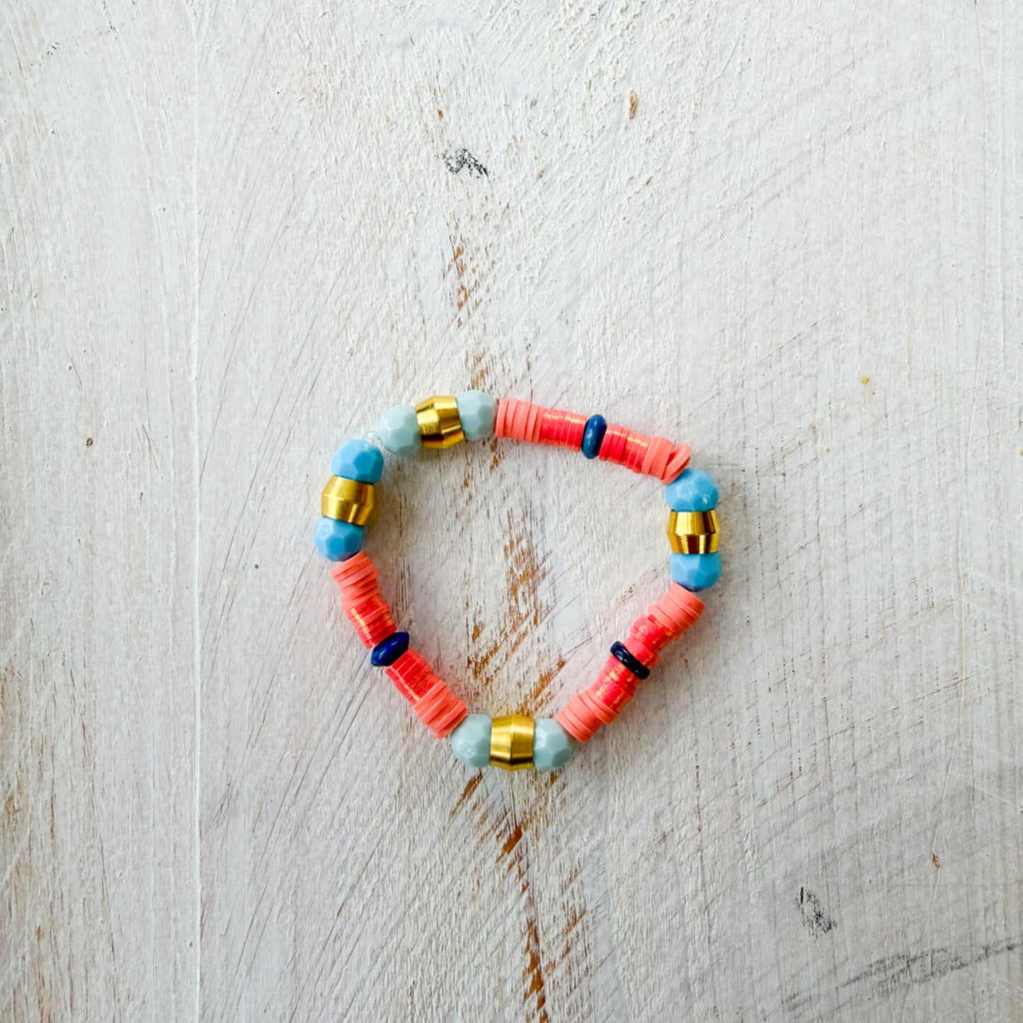 Colorful beaded bracelet on a light wooden surface