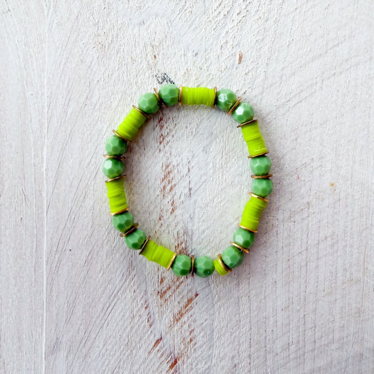 Green beaded bracelet on a light wooden surface