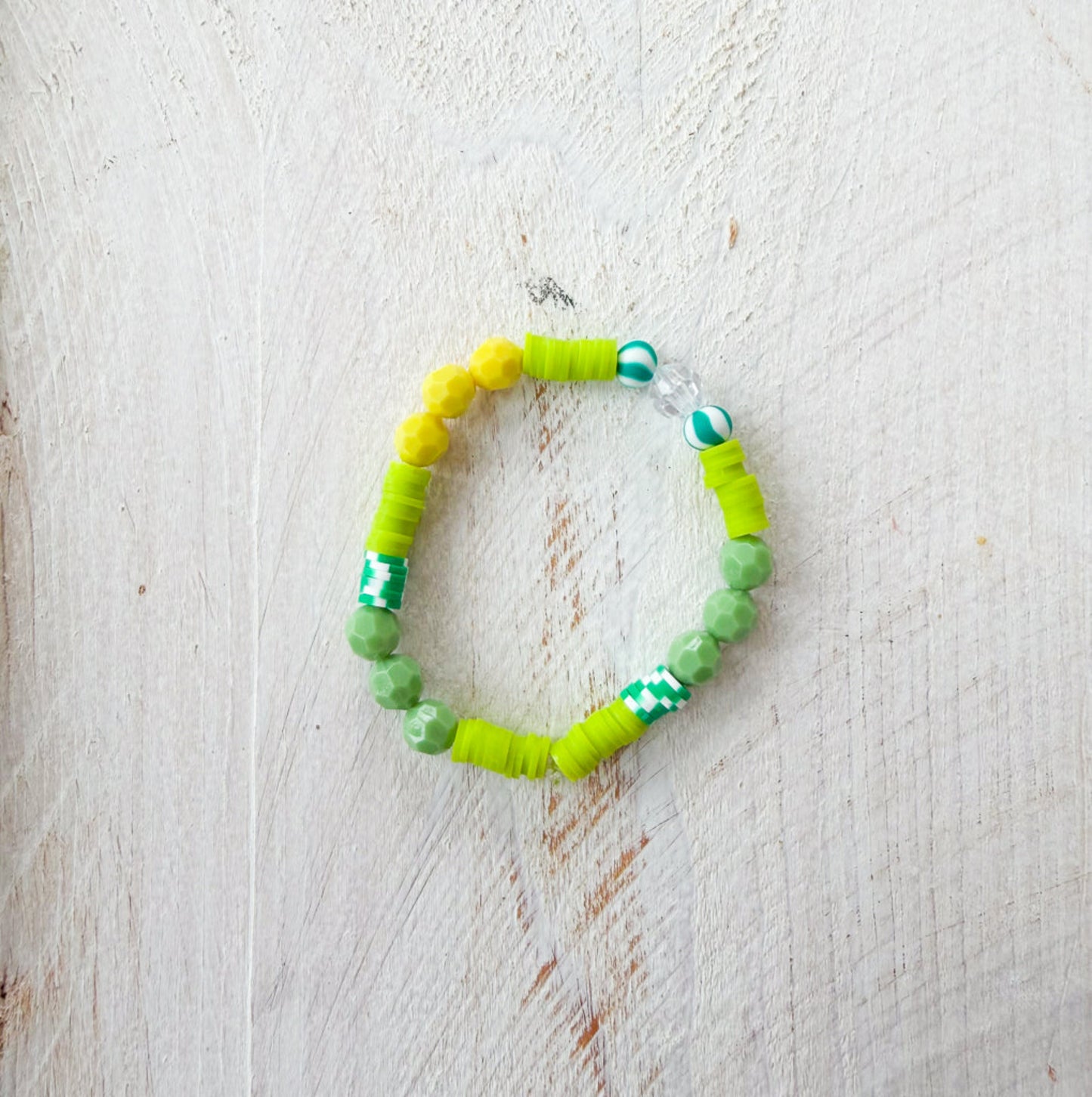 Green beaded bracelet on a light wooden surface