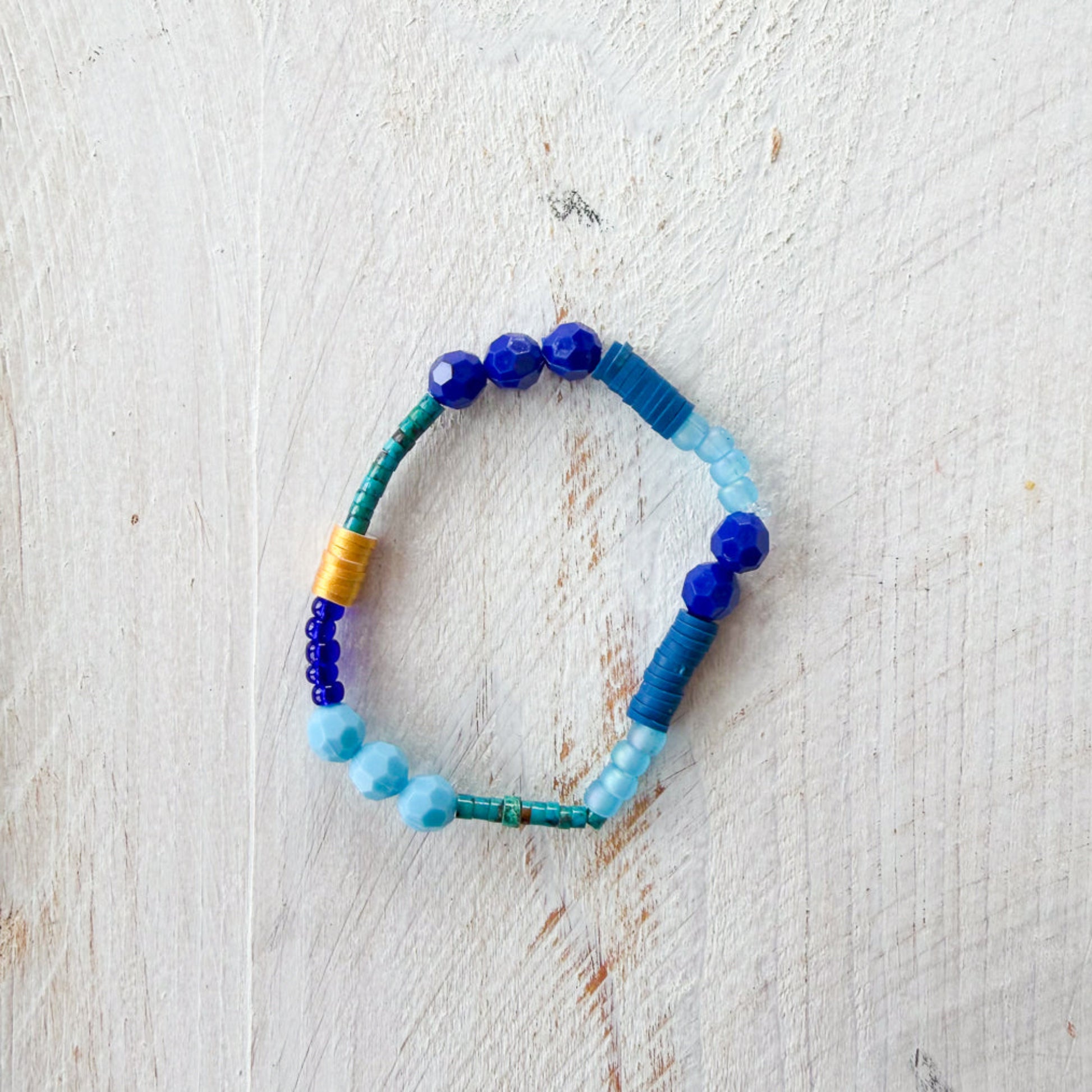 Colorful beaded bracelet on a light wooden surface