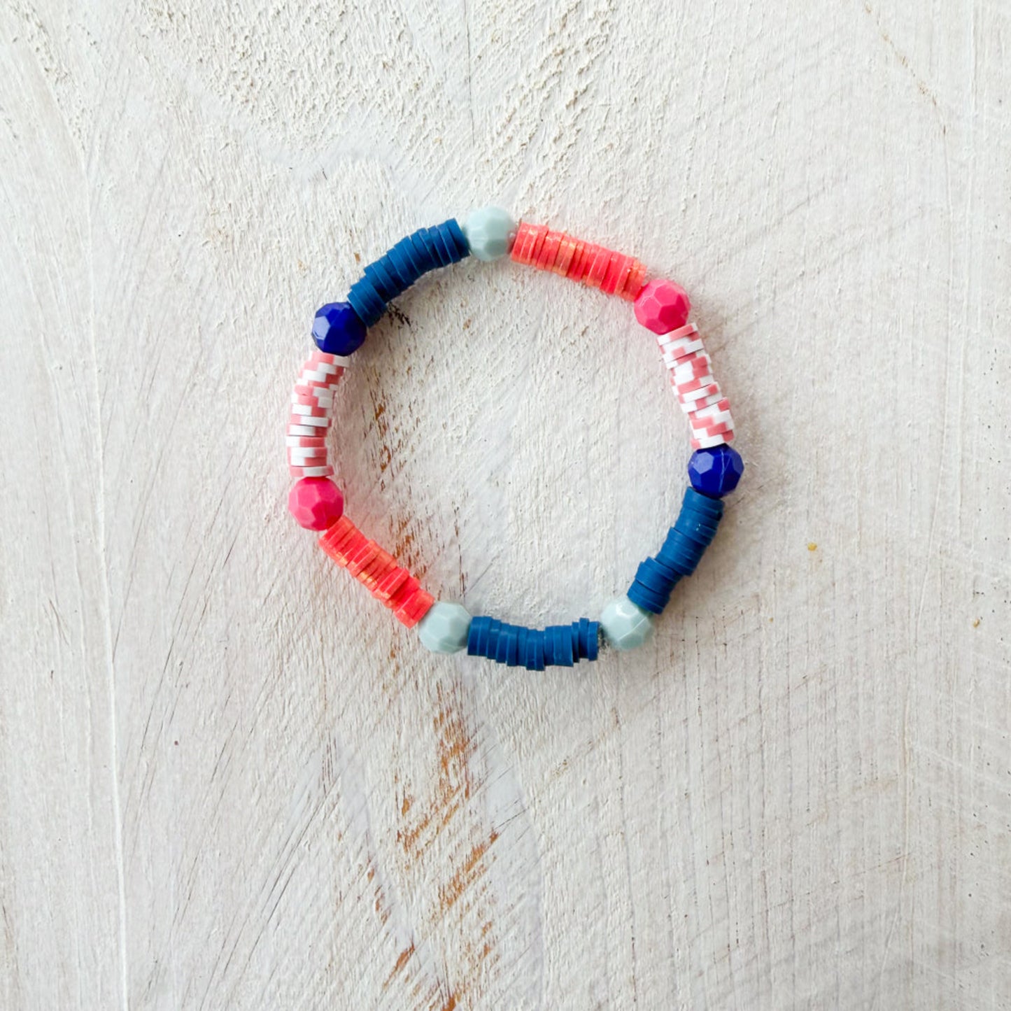 Colorful beaded bracelet on a light wooden surface