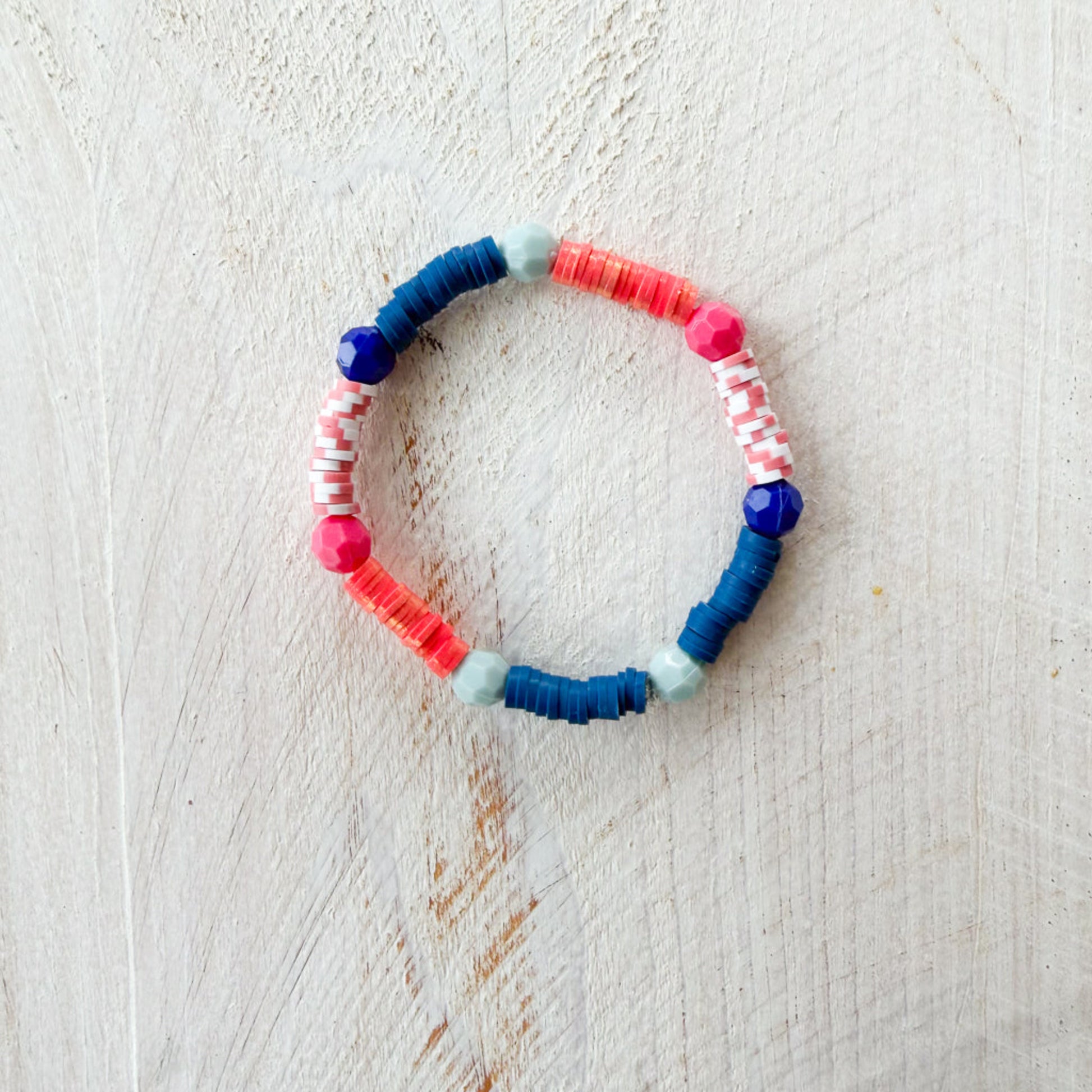 Colorful beaded bracelet on a light wooden surface