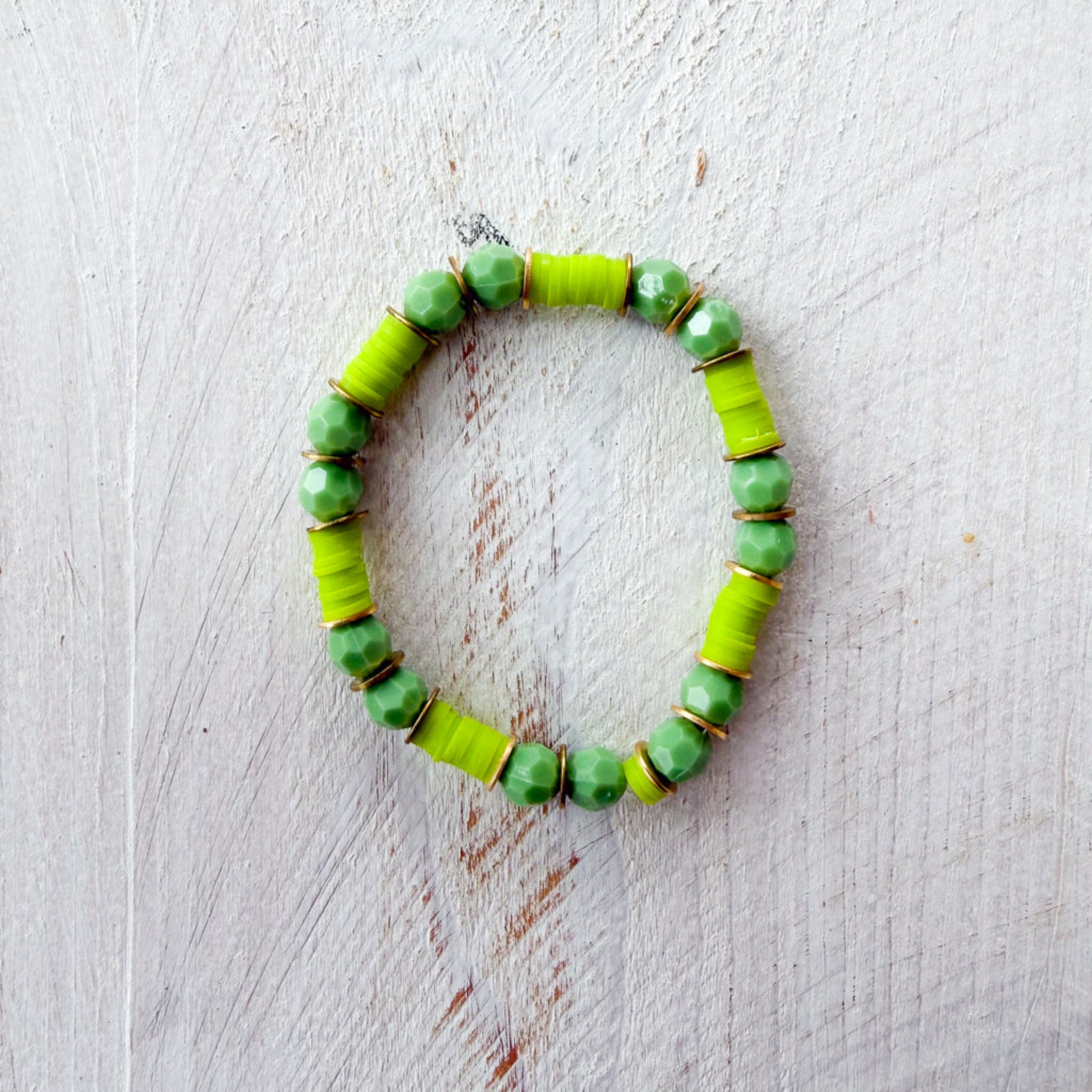 Green beaded bracelet on a light wooden surface