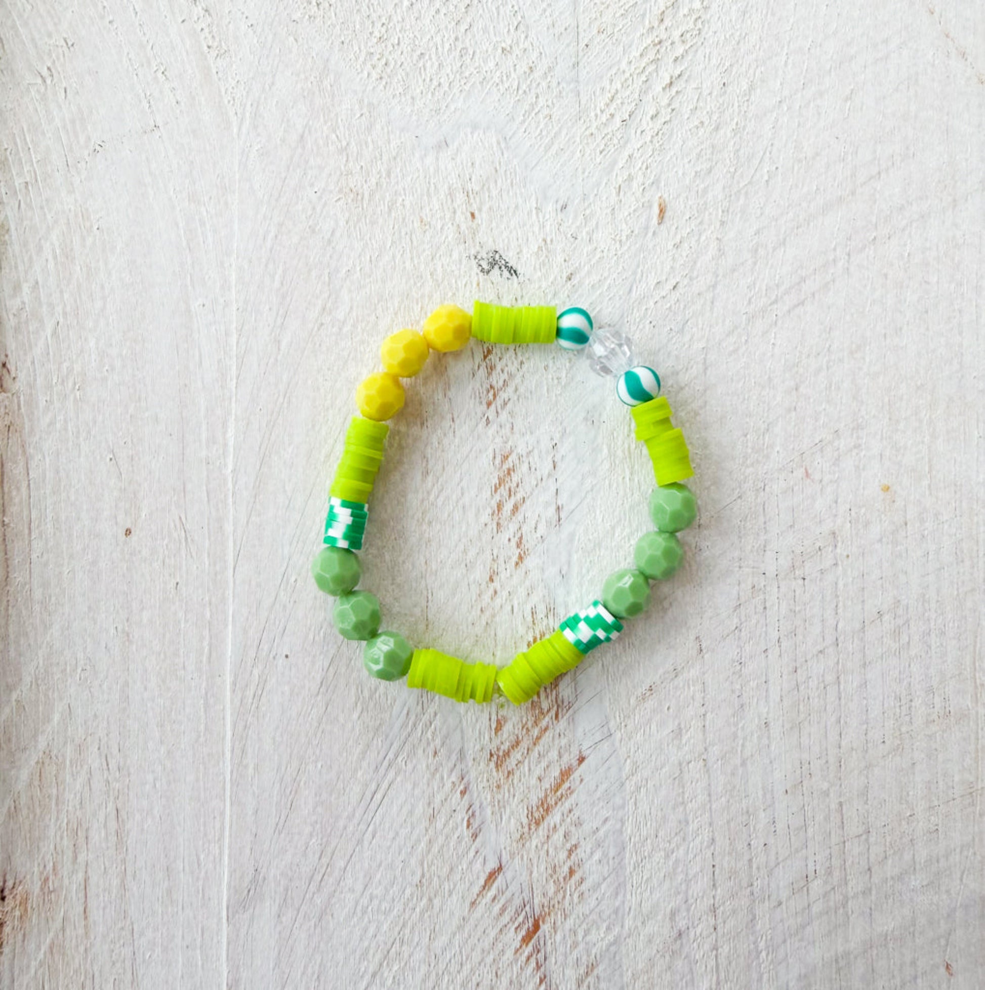 Green beaded bracelet on a light wooden surface