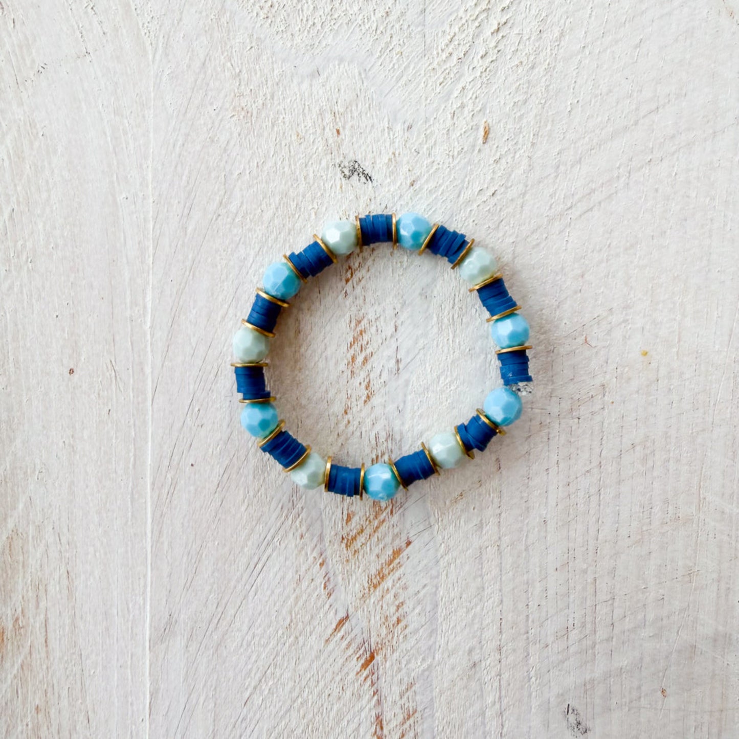 Blue and green beaded bracelet on a light wooden surface