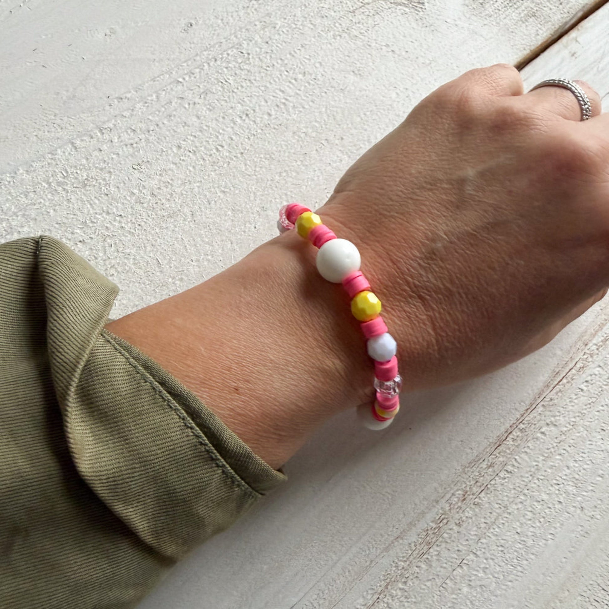 Hand wearing a colorful beaded bracelet