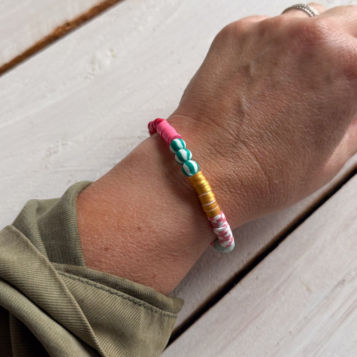 Colorful beaded bracelet on a wrist with a wooden surface background