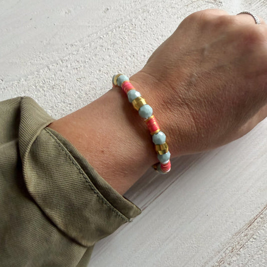 Multicolored beaded bracelet on a wrist with a neutral background