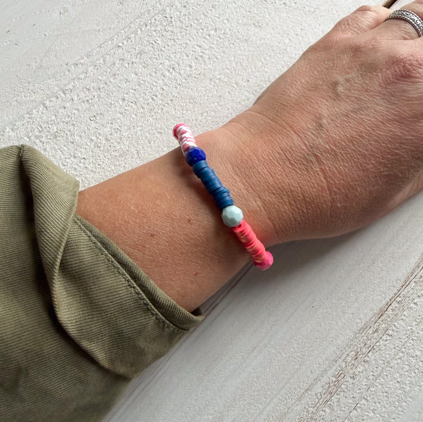 Colorful beaded bracelet on a wrist with a neutral background